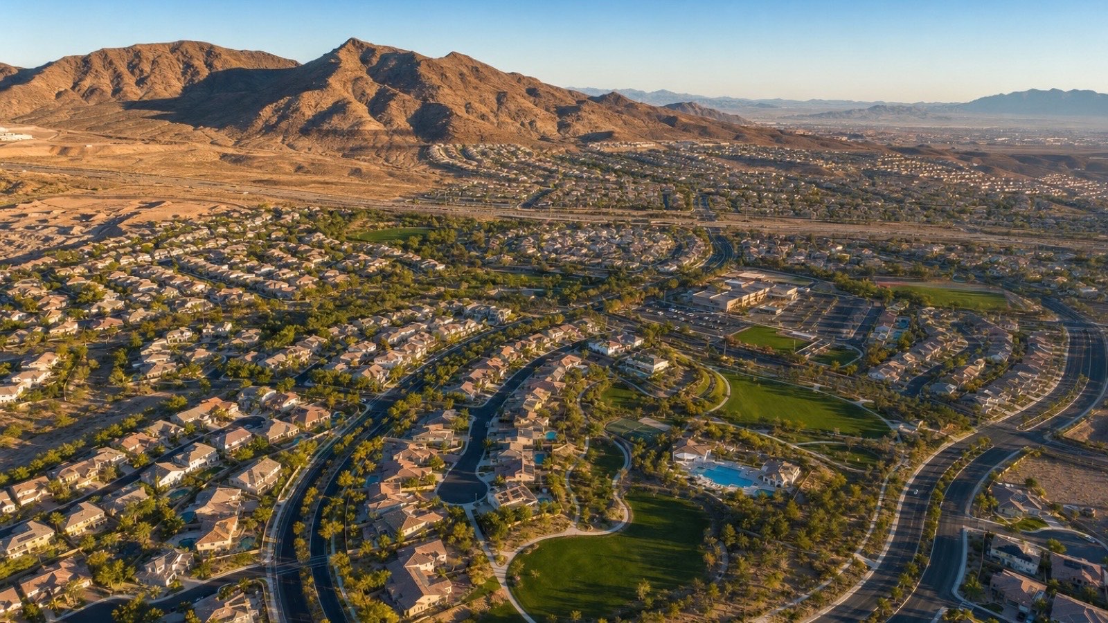 Custom estate home in Henderson Nevada with mature landscaping, three-car garage, and mountain views representing premium HOA community living